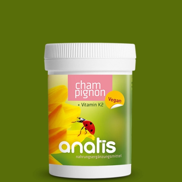 Rundes Produkt-Dosen-Etikett der Marke anatis: weiße Zuckerrohrdose mit grün-gelbem Etikett, darauf ein gelbe Blume und ein Marienkäfer, Schriftzug ‚anatis Nahrungsergänzungsmittel‘ sowie der Produktname ‚Champignon + Vitamin K2 Vegan‘.