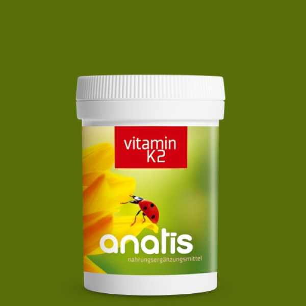 Weiße Zuckerrohr-Dose mit grün-gelbem Etikett und rotem Schriftfeld ‚vitamin K2‘ sowie dem Anatis-Logo und einem Marienkäfer auf Blumenmotiv vor einfarbig grünem Hintergrund.